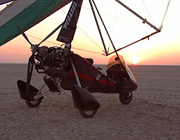 The sun rises behind the Pegasus microlight